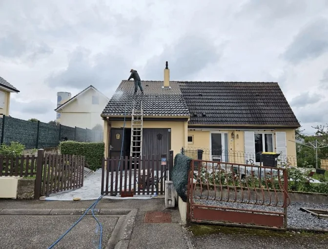 Couvreur de l'entreprise toitures lux welter procédant au démoussage d'une toiture au luxembourg